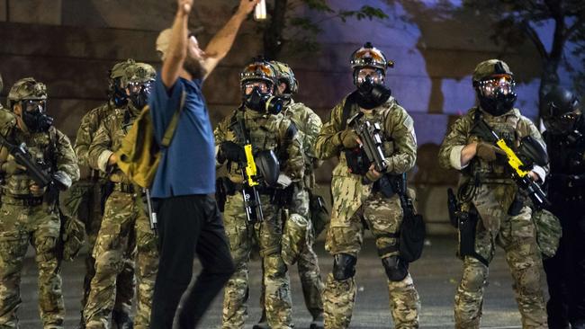 A protester walks past a group of officers. Picture: Nathan Howard/Getty Images/AFP