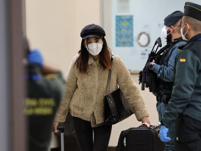 A passenger of a flight from Beijing leaves the terminal after landing at the Adolfo Suarez Madrid-Barajas airport. Picture: AFP