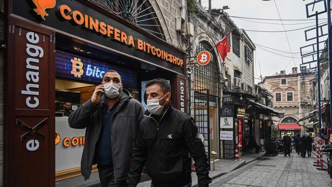 People pass in front of a cryptocurrency shop near the Grand Bazaar in Istanbul. Picture: AFP