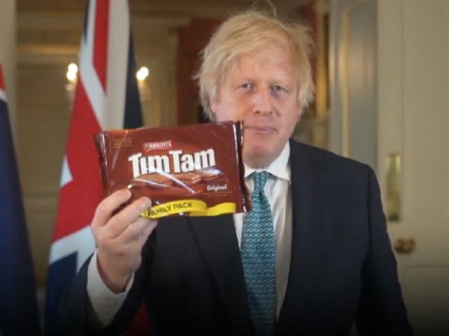 Boris Johnson holds up a packet of Tim Tams as he spruiks a free trade deal between Australia and the UK.