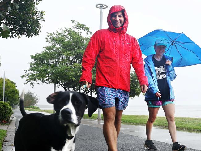 The wet season continues to persist in Far North Queensland, with rainy weather forecast to continue for the remainder of the week. Josh Hayes and Sally Speare take their dog Clancy for a walk in the rain along the Cairns Esplanade. Picture: Brendan Radke