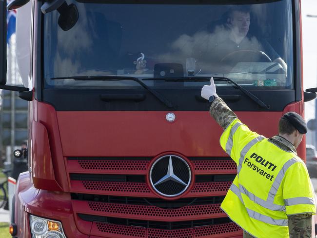 A policeman gestures after checking a vehicle, at the border by Moellehus in Denmark as the borders closed. Picture: APP