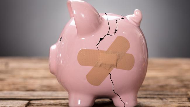 Closeup of broken pink piggybank with bandage on wood, savings generic, cracked and band aid