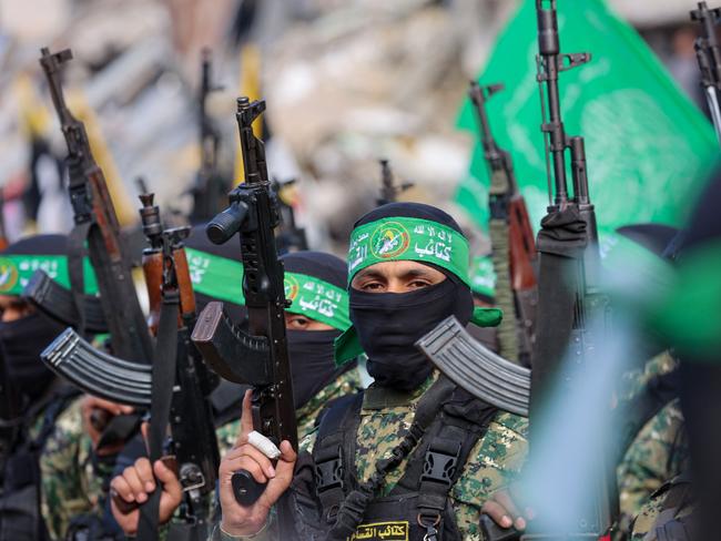 Hamas fighters secure an area in a square before handing over four Israeli hostages to a Red Cross team in Gaza City on January 25, 2025. Four freed Israeli women hostages were home in Israel January 25, ending more than 15 months of captivity after Hamas militants handed them over to the Red Cross under a truce deal in the Gaza war. (Photo by Omar AL-QATTAA / AFP)