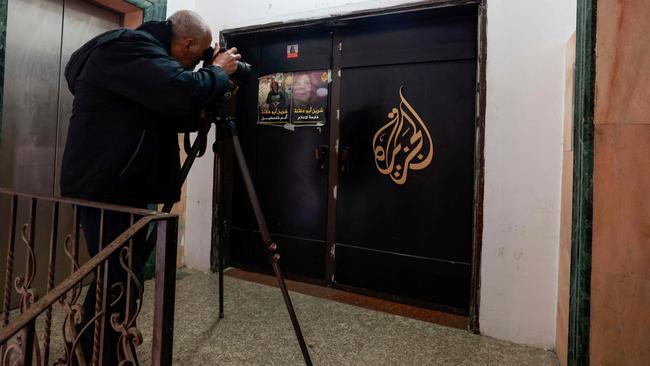 A man photographs the closed door of the Al-Jazeera TV channel in the occupied-West Bank city of Ramallah on Thursday after the Palestinian Authority ordered the suspension of broadcasts by Al Jazeera across the Palestinian territories. Picture: AFP