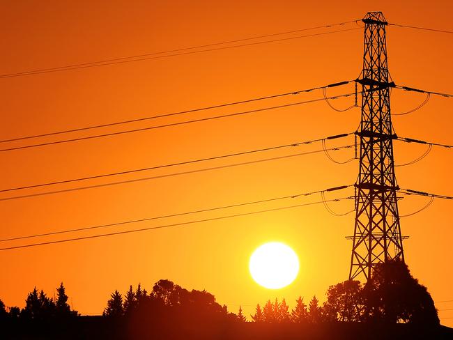 The sun sets behind powerlines in the west of Melbourne, Victoria. *power, electricity, energy* Picture: Mark Stewart