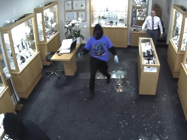 The manager pursues one of the bandits out of the store..