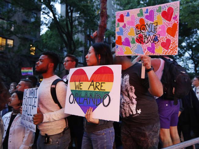 People hold up homemade signs during a vigil and memorial for victims of the Orlando nightclub shooting at the historic Stonewall Inn gay bar, in New York. Picture: AP