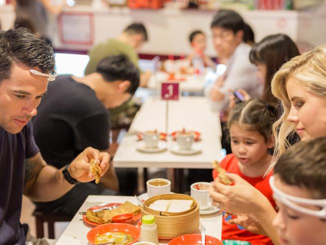 Michael and Carlene Duffy with children Stella and Paddy using EEG headsets while enjoying a Singapore breakfast of kaya toast.