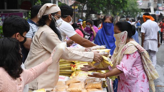 A Hindu priest along with volunteers distribute grocery items to people in need after the government eased a nationwide lockdown as a preventive measure against the COVID-19 coronavirus in Amritsar, India. Picture: AFP