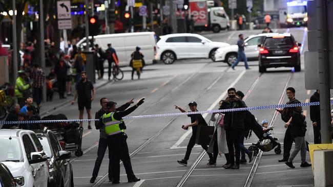 Police are seen redirecting pedestrians away from an incident on Bourke Street. Picture: James Ross/AAP