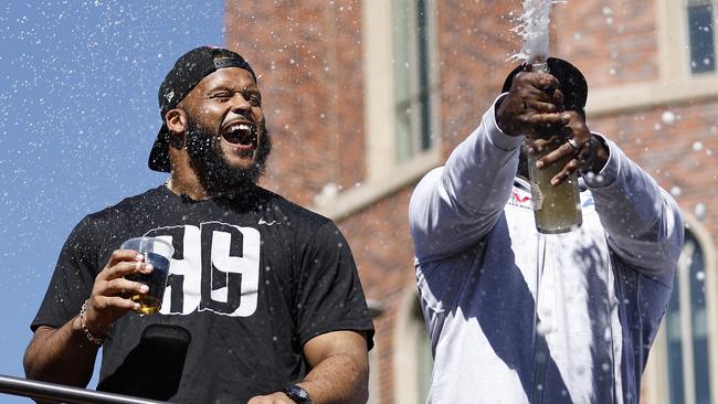 LOS ANGELES, CALIFORNIA - FEBRUARY 16: Aaron Donald #99 of the Los Angeles Rams (L) celebrates with champagne during the Super Bowl LVI Victory Parade on February 16, 2022 in Los Angeles, California. Michael Owens/Getty Images/AFP == FOR NEWSPAPERS, INTERNET, TELCOS &amp; TELEVISION USE ONLY ==