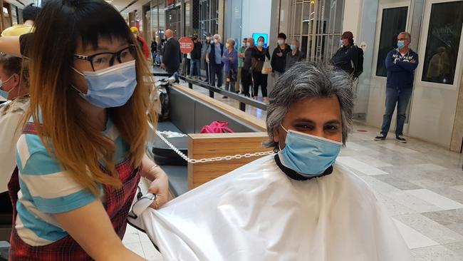 BEFORE: Heidelberg West's Damian D'Sousa sits down for a haircut at Eastland, five months since his last one. Picture: Kiel Egging.