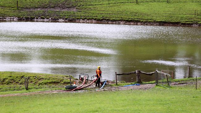 SES crews begin to pump water from the dam the day before it was declared safe. Picture: Kelly Barnes