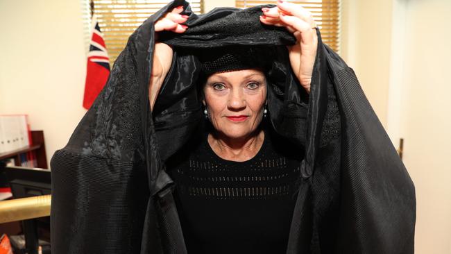 One Nation senator Pauline Hanson putting on a burqa in her parliamentary office before entering the Senate chamber yesterday. Picture: Gary Ramage