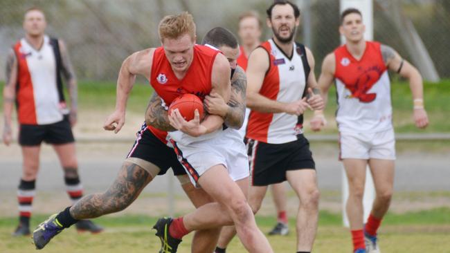 Flagstaff Hill's Casey Davies is tackled by Christies Beach’s Rhys Mundy during the sides’ clash on Saturday. Picture: AAP/Brenton Edwards