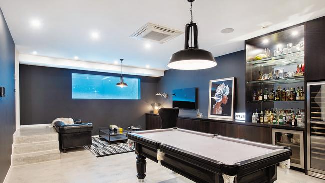 The “man cave” in their Brighton home has a window into the pool.