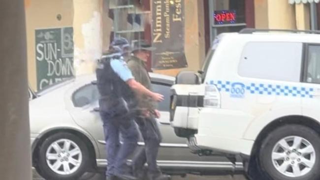 Andrew Thaler is led away by police following the alleged confrontation in Nimmitabel on Sunday. Picture: Supplied / Facebook