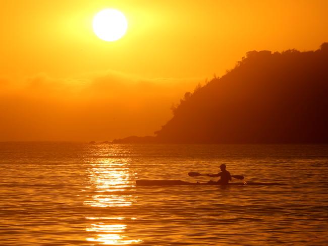 Balmoral Beach at sunrise gave a glimpse of the toasty day ahead. Picture: John Grainger