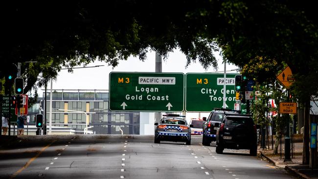 Police vehicles are seen on a deserted street on the first day of a snap lockdown in Brisbane. Picture: AFP