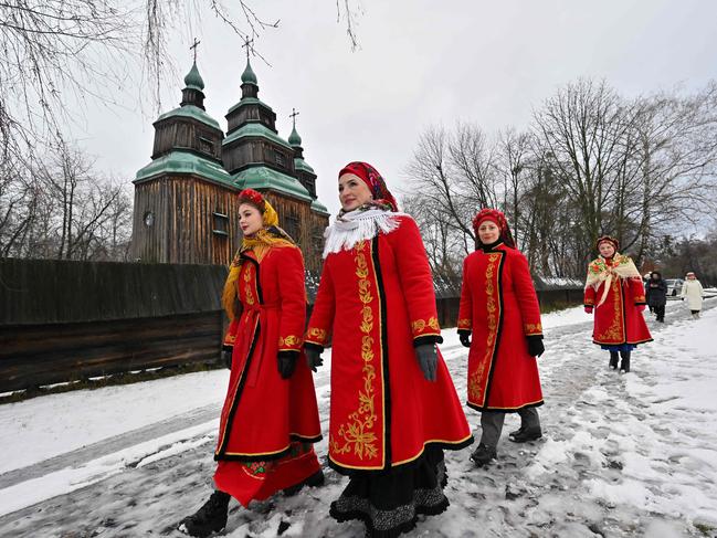 Women, wearing traditional Ukrainian clothes, walk in a snow-covered street as they take part in Christmas celebrations in the village of Pyrogove, near Kyiv. Picture: AFP