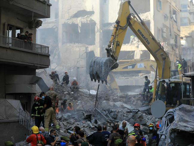 Rescuers use an excavator to search the rubble of the building. Picture: AFP