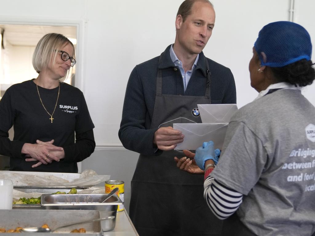 Volunteer Rachel Candappa hands get well soon cards to Prince William for his wife and King Charles. (Photo by Alastair Grant-WPA Pool/Getty Images)