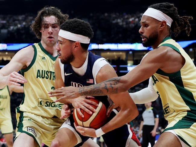 ABU DHABI, UNITED ARAB EMIRATES - JULY 15: Devin Booker #15 of the United States competes for the ball with Josh Giddey #3 and Patty Mills #5 of Australia during the second half of an exhibition game between the United States and Australia ahead of the Paris Olympic Games at Etihad Arena on July 15, 2024, in Abu Dhabi, United Arab Emirates. (Photo by Christopher Pike/Getty Images)