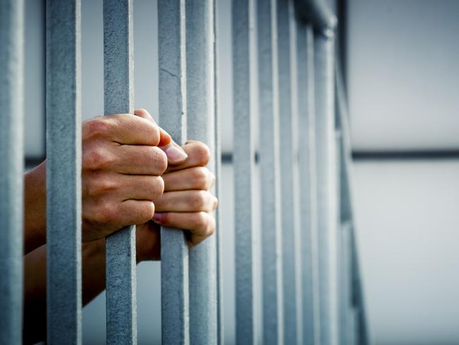 Generic photo of hands in jail cell.