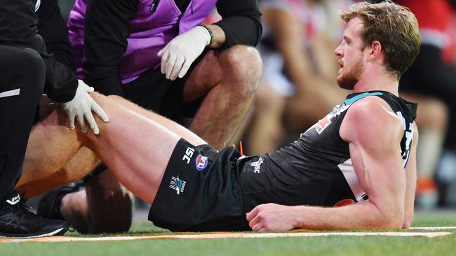 Tom Jonas of the Power has his leg checked by medical staff. Picture: AAP