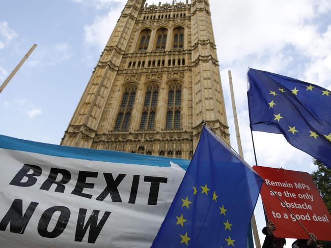 Pro-Brexit and anti-Brexit campaigners with banners and EU flags are seen outside the Houses of Parliament in London. Picture: AFP