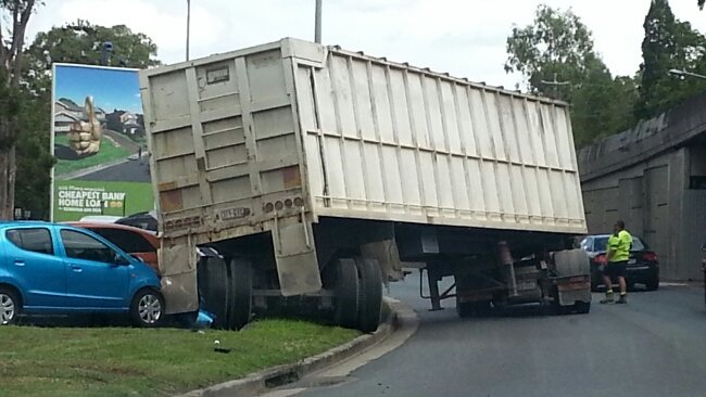 Truck drives over parked car on Toowong roundabout | The Courier Mail