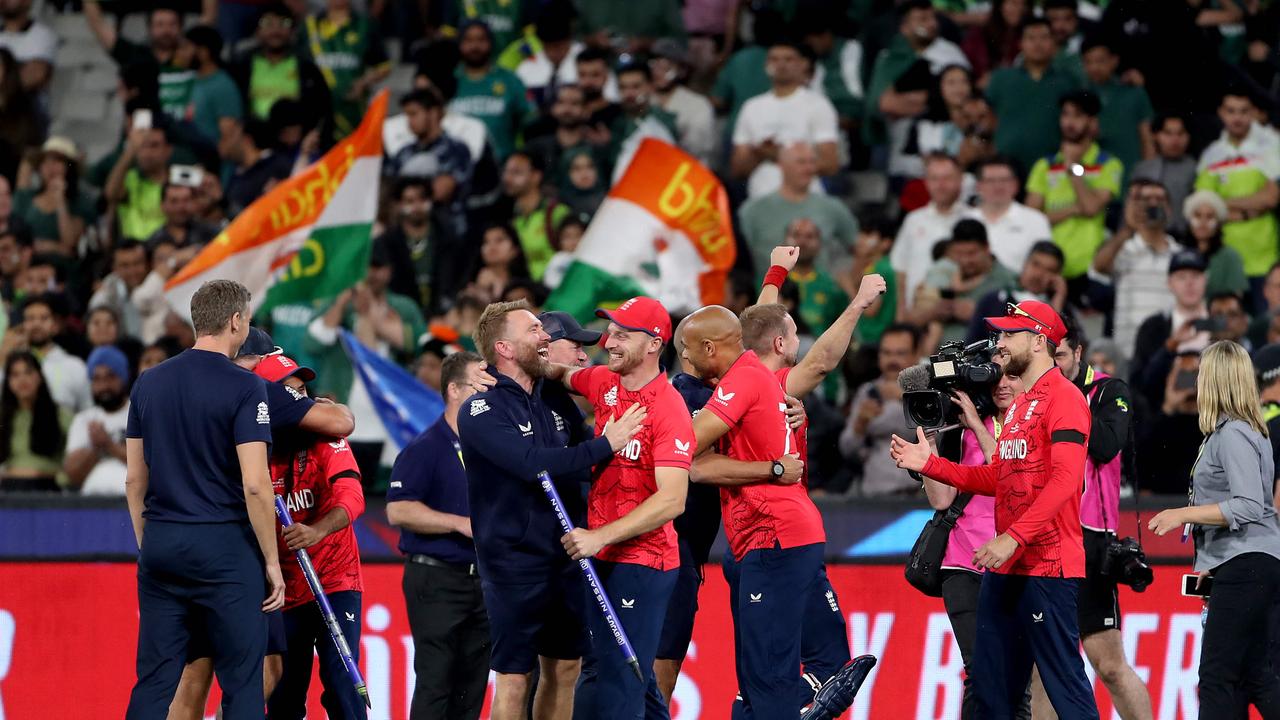 England's Captain Jos Buttler (C) celebrates with teammates and staff.