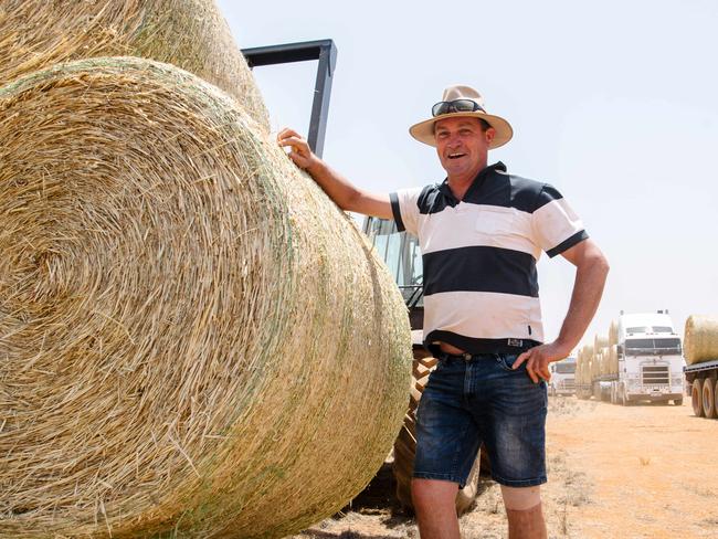 Stephen McKeough with the hay that is being unloaded from trucks. Muslim Aid Australia has organised one of the biggest hay drops in SA, with about 20 trucks delivering fodder to drought stricken farmers in Petersborough, Saturday, December 21, 2019. (AAP Image/ Morgan Sette)