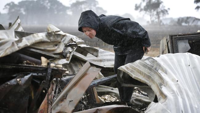 Newlywed Rebecca Jones searching through the ashes of her recently-renovated home near Cobden yesterday. Picture: David Caird.