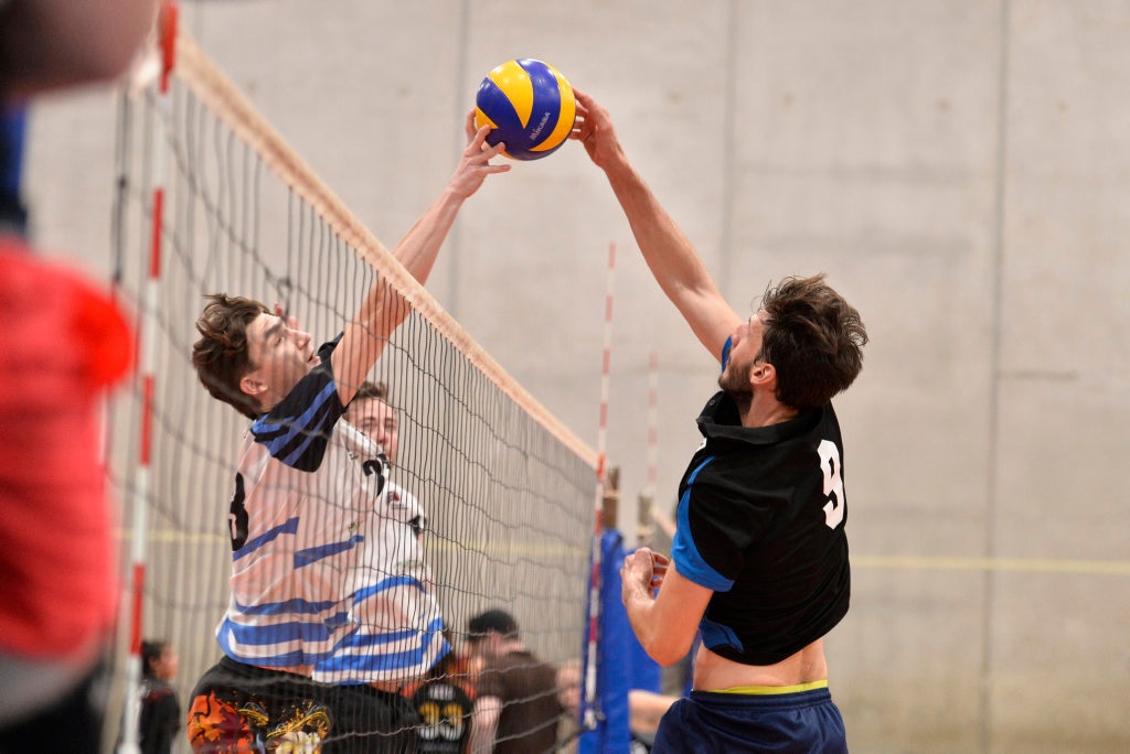 Brisbane Volleyball Club player Connor Rudder (left) and Remember the Titans player Marco Calderini at the net in the final of the Clash of the Titans volleyball tournament at Harristown State High School gym, Sunday, February 25, 2018. Picture: Kevin Farmer