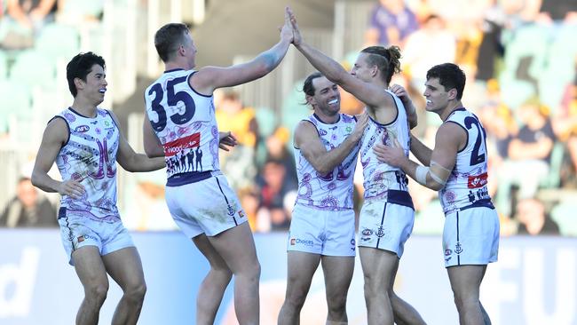 Nat Fyfe after kicking a goal in his 200th game as his teammates join the celebrations. Picture: Getty Images