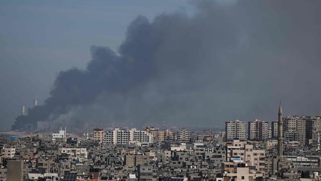 Smoke billows over the Israeli side of the border with Gaza as seen from Gaza City on October 7 following a series of early morning rocket attacks from the Gaza Strip into Israel.