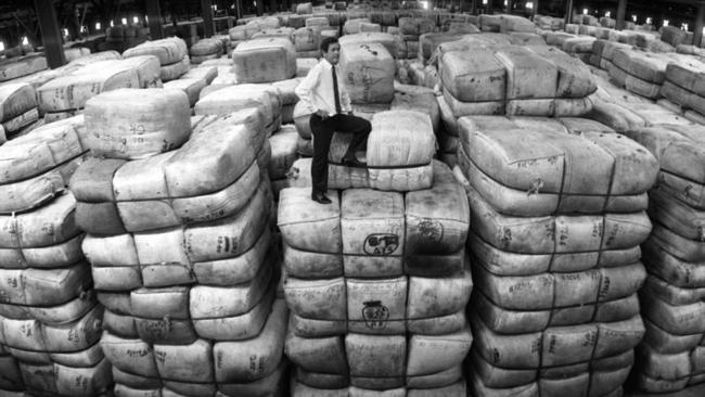 Australian Wool Corporation state assistant manager Lionel Viney standing on wool stockpile at store in Hendra 03 Oct 1991.