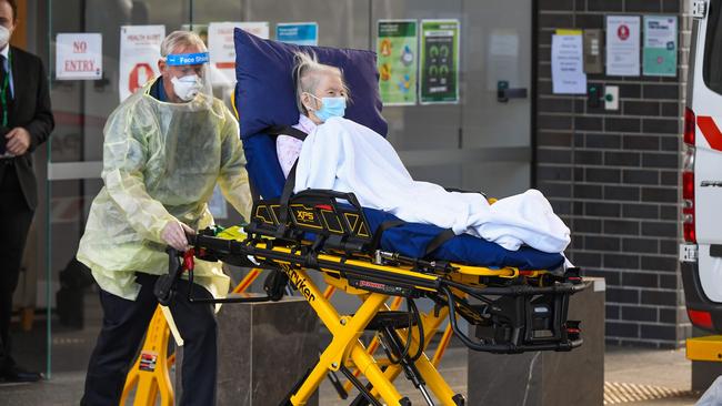 Medical workers evacuate a resident from the Epping Gardens aged care facility in the Melbourne suburb of Epping on July 30, 2020, as the city battles fresh outbreaks of the COVID-19 coronavirus. (Photo by William WEST / AFP)