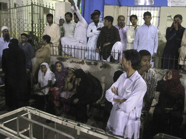 People gather outside an emergency ward of a local hospital after hearing news of a bomb blast at a Sufi shrine, in Karachi, Pakistan.  Picture:  AP