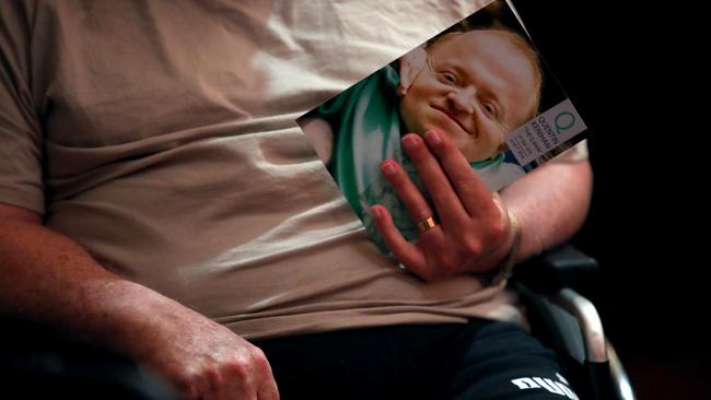 A mourner holds the memorial booklet at Quentin Kenihan’s memorial service on Sunday. Picture: AAP / Kelly Barnes