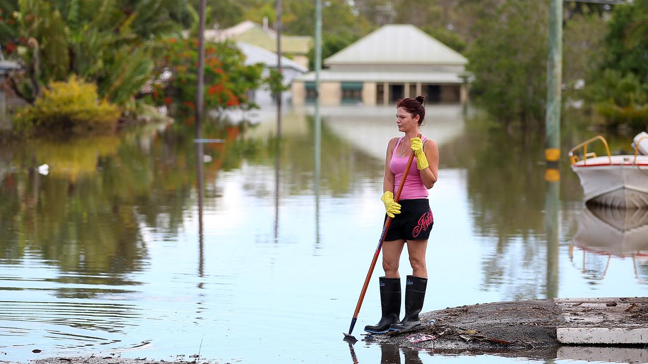 BUNDABERG, AUSTRALIA - JANUARY 30: Residents clean up debris in their street as parts of southern Queensland experiences record flooding in the wake of Tropical Cyclone Oswald on January 30, 2013 in Bundaberg, Australia. Flood waters peaked at 9.53 metres in Bundaberg yesterday and began receding overnight, as residents and relief teams prepare to clean-up debris. Four deaths have been confirmed in the Queensland floods and the search is on for two men though to be missing in floodaters in Gatton. (Photo by Chris Hyde/Getty Images)