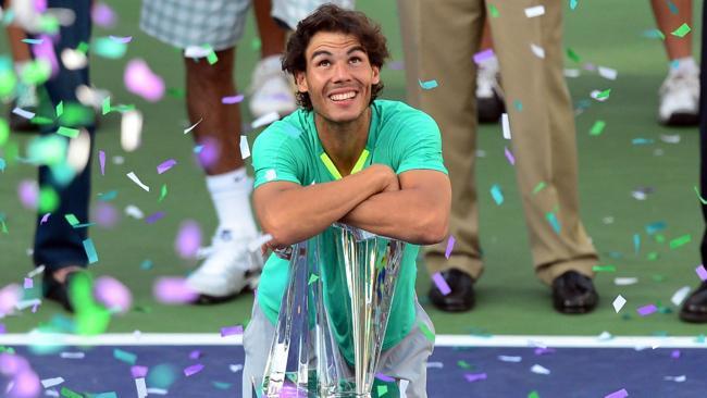 Nadal rests on the championship trophy after defeating Juan Martin Del Potro of Argentina in three-sets in the men's tennis final at the BNP Paribas Open. AFP PHOTO/Frederic J. BROWN