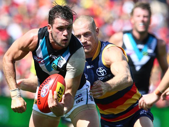 Travis Boak gets his handball away, ahead of a tackle from Scott Thompson. Picture: Sarah Reed.