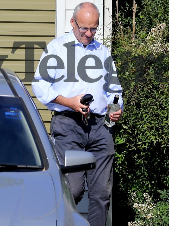 Fully dressed, Mr Foley leaves his home with clutching a $30 bottle of Nemiroff vodka. Picture: John Grainger