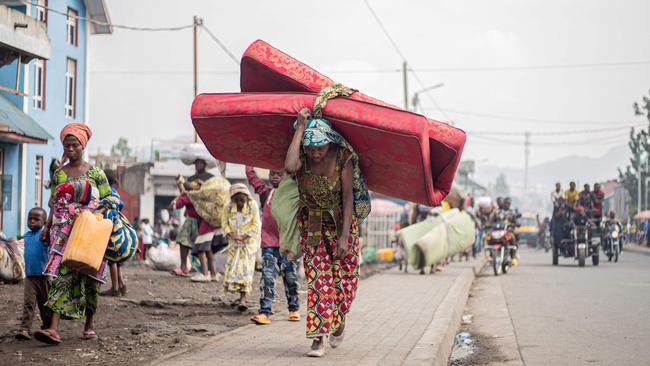 A woman flees from Kibati, where fighting has intensified, towards the city of Goma. Picture: AFP