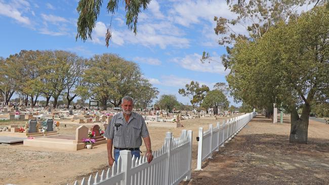 Cr Geoff McMullen with the new Roma Cemetery fencing after Laurie caused significant damage.