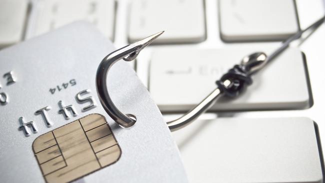 phishing - fish hook with a credit card on white computer keyboard credit card fraud generic, scammers, theft