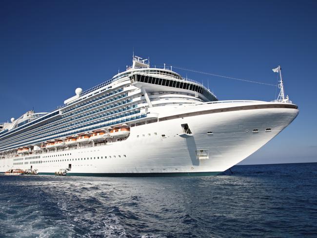 Eastern Caribbean Sea - February 8, 2010: A luxury cruise ship anchors in the water as passengers are taken by ferry to the local tropical island for a day of sun and fun.